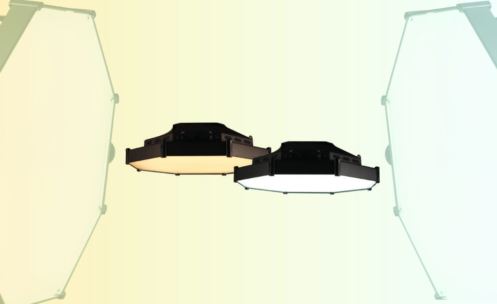 Two hexagonal ceiling lights hang side by side, one with a warm yellow glow and the other cool white light—perfect for enhancing video or lighting setups. Softly lit panels frame both sides against a pastel-toned background.